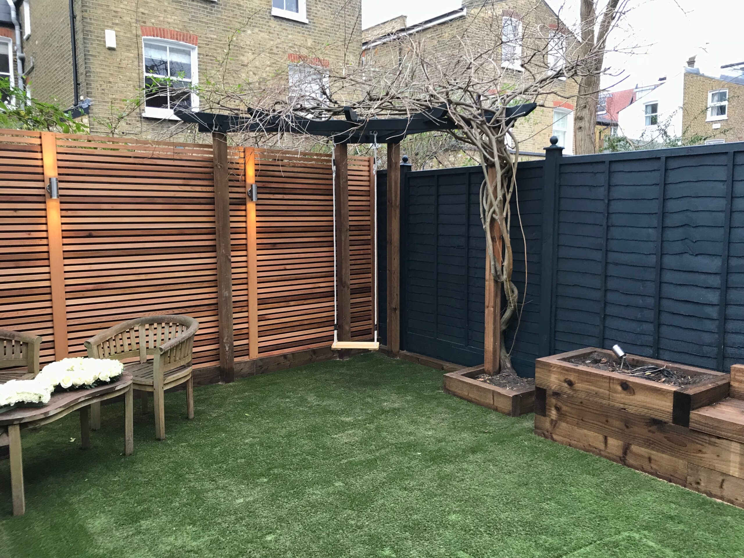 A neat garden transformation - including uplighting along fencing and a swing!